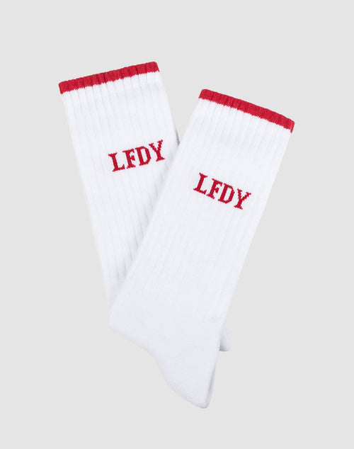 A 2-pack of LIVE FAST DIE YOUNG Basic Stripe Socks in white with red cuffs and LFDY embroidered in red. Made from soft cotton, One Size fits all. The socks are shown overlapping on a plain gray background.