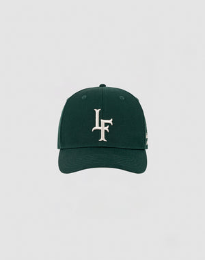 The LF Snapback by LIVE FAST DIE YOUNG is a dark green cap with a bold white LF logo embroidered on the front and a Mit Snapverschluss, shown against a plain light gray background. Model: LF2308-14417.