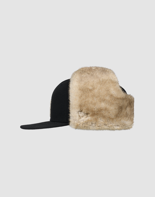 The LFDY x New Era 59Fifty DogEar by LIVE FAST DIE YOUNG features warm beige faux fur ear flaps and the iconic New Era Flag, shown against a light gray background.
