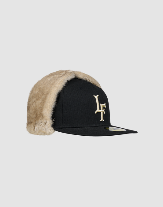 The LFDY x New Era 59Fifty DogEar by LIVE FAST DIE YOUNG is a fitted cap with beige faux fur lining, ear flaps, an off-white LF logo on front, and New Era Flag detail, shown with a flat brim on a plain grey background.