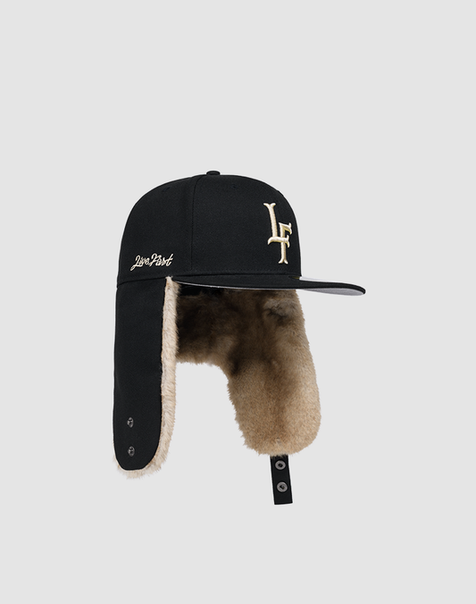 The LFDY x New Era 59FIFTY DogEar by LIVE FAST DIE YOUNG is a fitted cap with brown faux fur ear flaps, “LF” front embroidery, New Era side flag, “Don’t Fold” in white, flat brim, and a snap-button on the ear flap.