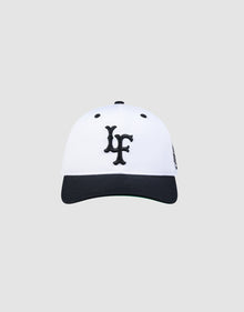 The LFDY Snapback by LIVE FAST DIE YOUNG features a white crown, black brim, black embroidered LF logo on the front, and a classic green underbrim, shown against a plain light grey background.