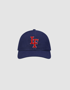 The LFDY Snapback by LIVE FAST DIE YOUNG features a navy blue design with a red and white embroidered “LF” Multi-Logo-Stick on the front, adjustable Snapverschluss, and Modell LF2605-20880. Displayed on a plain light gray background.