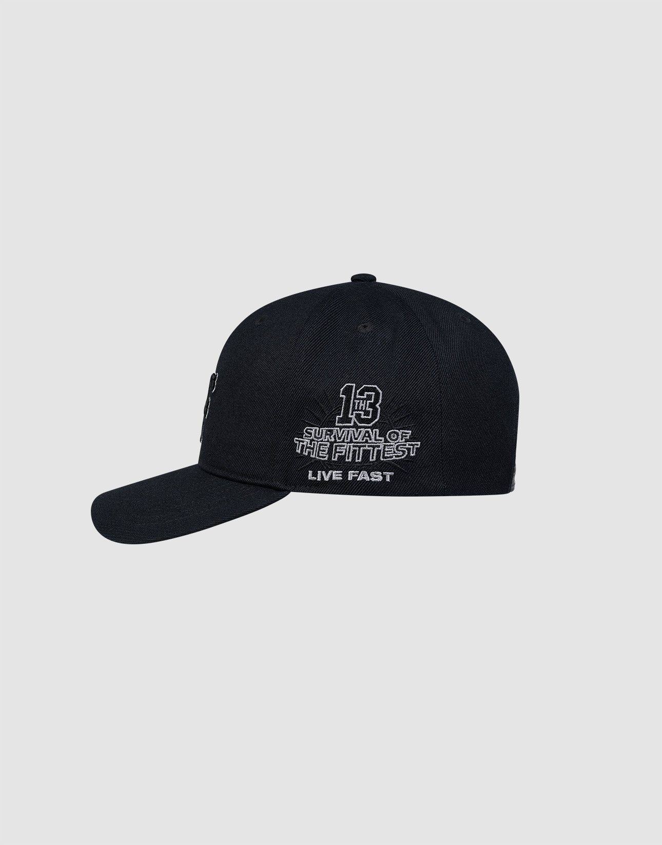 The LFDY Snapback by LIVE FAST DIE YOUNG is a black cap with a snap closure, white "13 Survival of the Fittest Live Fast" embroidery on the front, and a gray underside of the brim, shown against a plain light gray background.