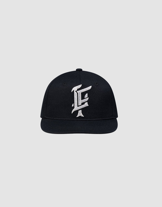 The LF Rhinestone Cap by LIVE FAST DIE YOUNG features a black cotton design with a bold white embroidered letter F on the front, showcased against a plain light gray background.