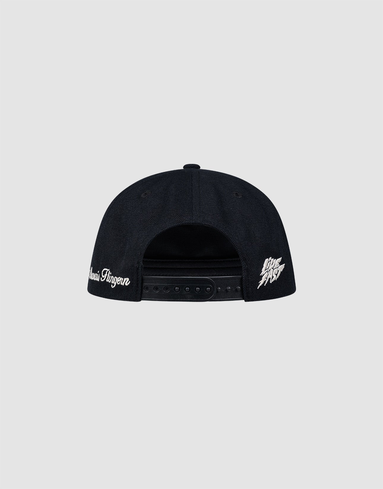 A black LF Rhinestone Cap by LIVE FAST DIE YOUNG is shown from the back, with white Logo-Stick text on the left side and a white graphic logo on the right, set against a plain light gray background.