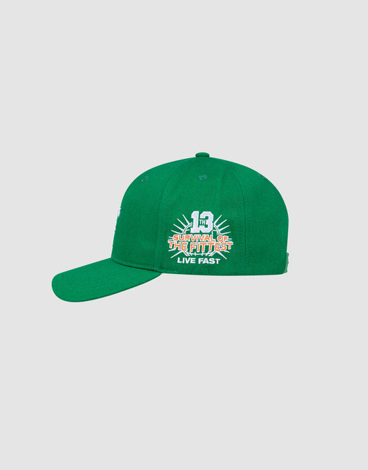 The LFDY Snapback by LIVE FAST DIE YOUNG is a green baseball cap with a curved brim, green underbill, and white/orange "Survival of the Fittest, Live Fast 1" embroidery on the front. Features a snap closure; shown on a plain background.
