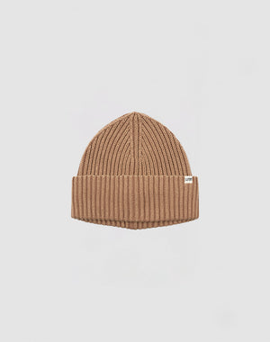 The LIVE FAST DIE YOUNG Rib Knit Beanie is tan, ribbed, one size, with a folded cuff and a small white flag label on the side, shown against a plain white background.