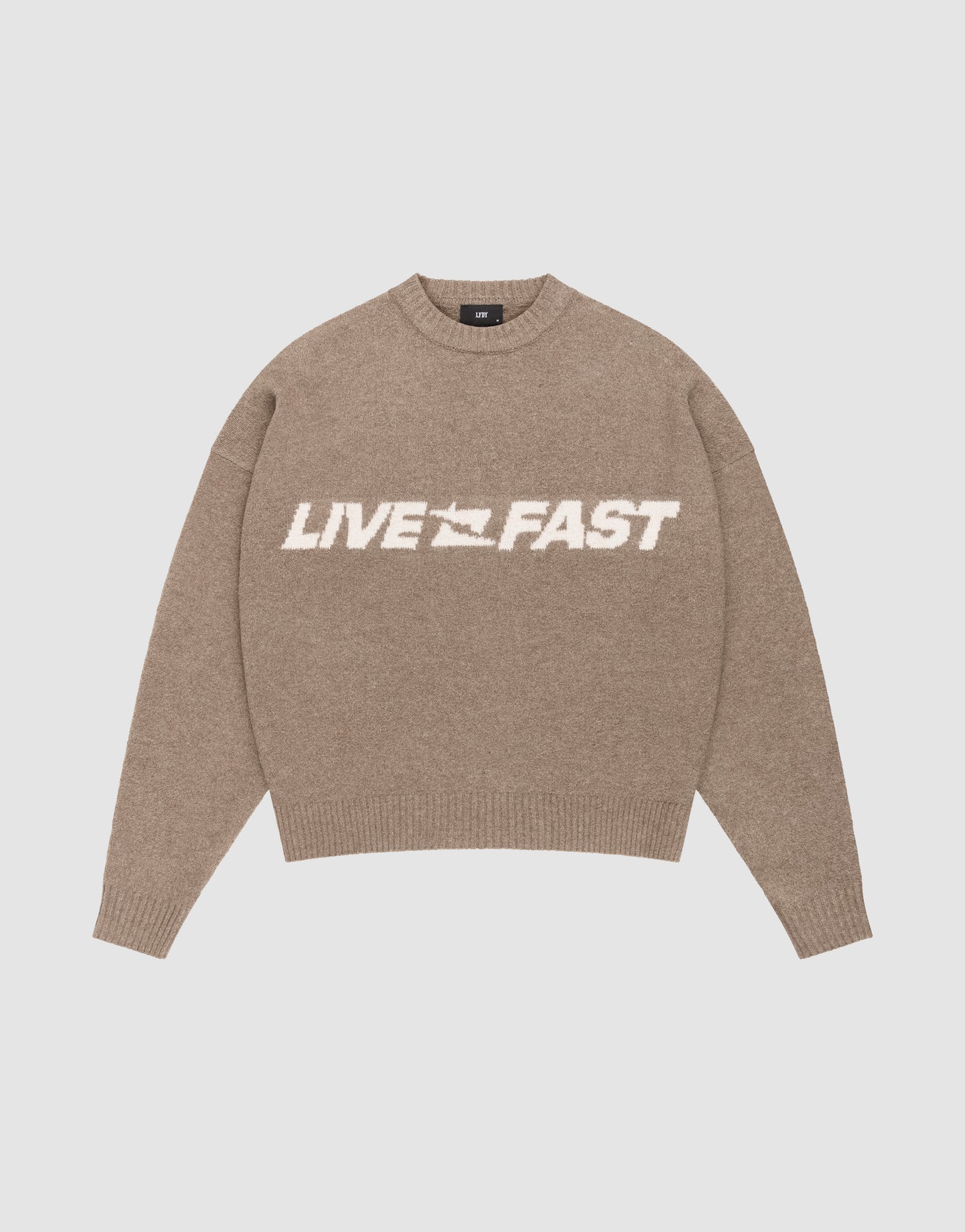 The Live Fast Boucle Sweater by LIVE FAST DIE YOUNG is a beige, oversize fit knit with long sleeves and ribbed trims. "LIVE FAST" in bold white and a speeding car graphic feature on the front for standout style.