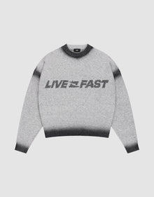 The Live Fast Boucle Sweater by LIVE FAST DIE YOUNG features a gray design with black cuffs, collar, and hem, bold “LIVE FAST” lettering across the front, and an oversize fit for a relaxed look. | plain