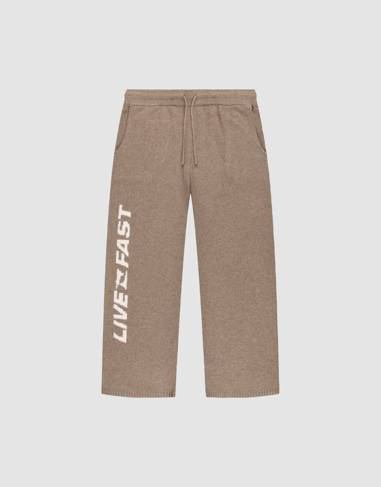 The Live Fast Boucle Pants by LIVE FAST DIE YOUNG are brown wide-leg sweatpants with a wide fit, elastic waistband (Elastikbund), drawstring, side pockets, and "LIVE FAST" boldly printed in white down the left leg.
