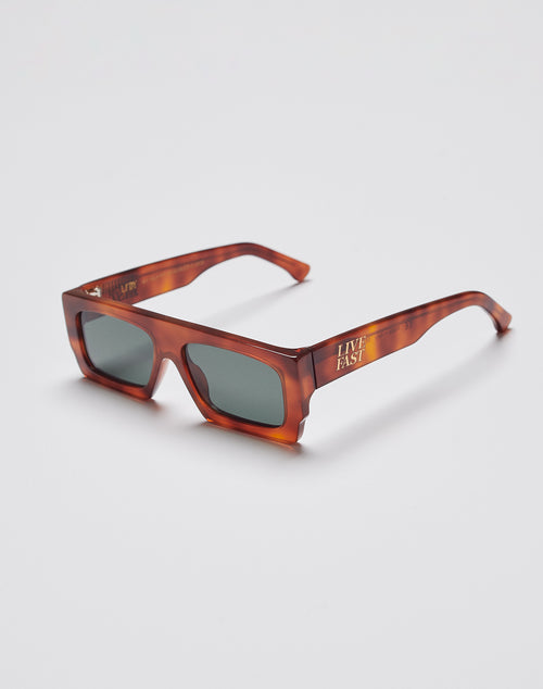 The Live Fast Shades by LIVE FAST DIE YOUNG are chunky rectangular tortoiseshell sunglasses made from premium Mazzuchelli Acetat, featuring dark UV-protective lenses and gold LIVE FAST text with the LFDY logo on the arms.