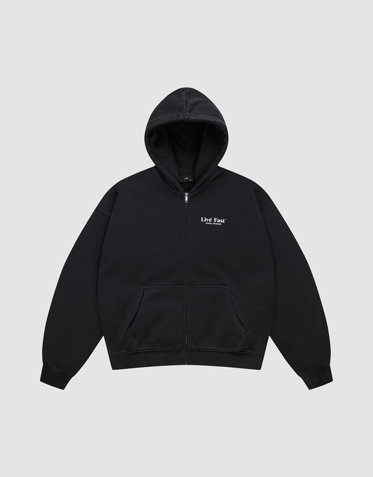 The LFDY Paris Hooded Zip by LIVE FAST DIE YOUNG is a black oversized zip-up hoodie with front pockets, a hood, and small white "Live Fast" text on the left chest, made from soft Baumwolle and shown on a light gray background.