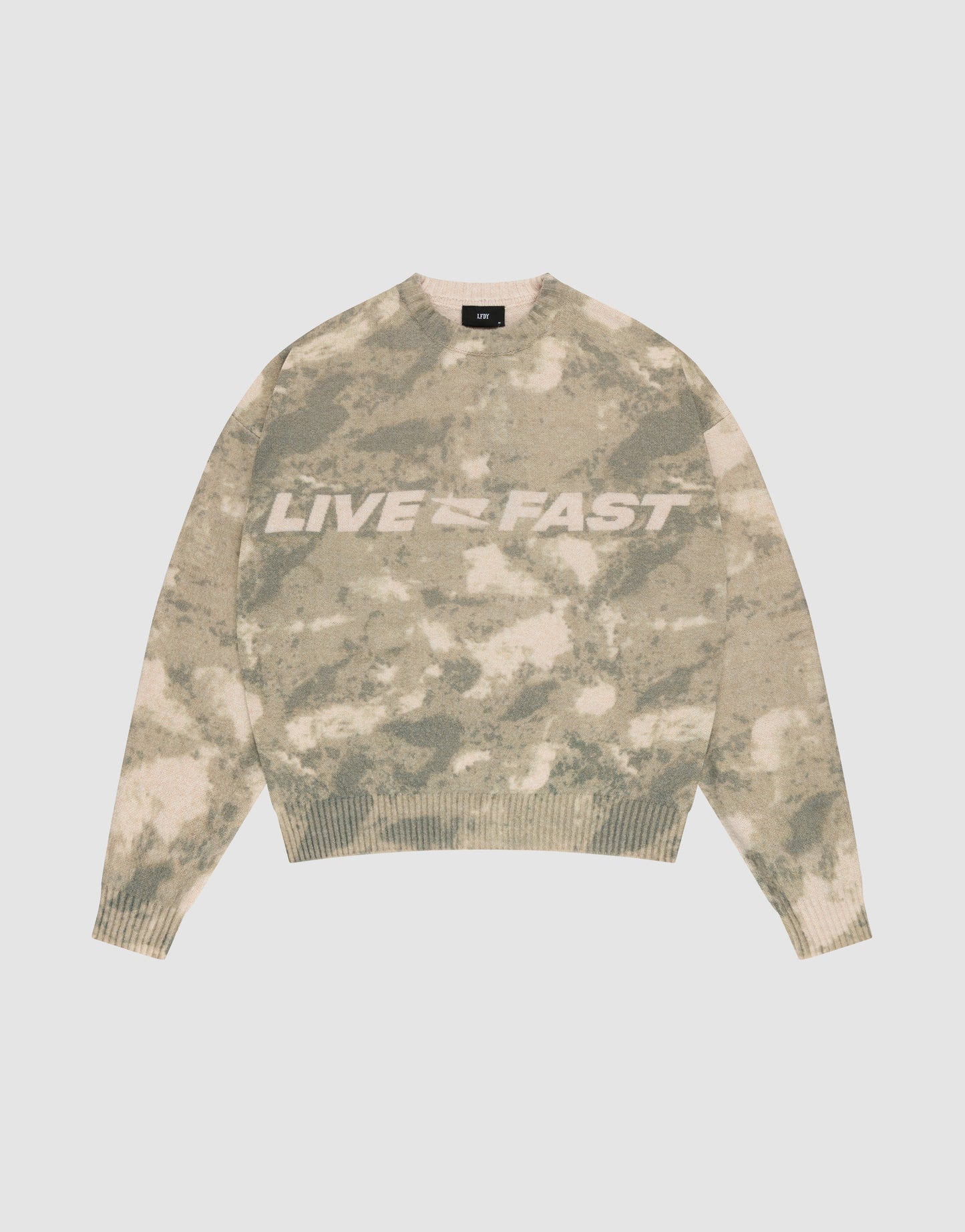 The Live Fast Boucle Sweater by LIVE FAST DIE YOUNG features a beige and green camo pattern, an oversized fit, and bold white "LIVE FAST" lettering across the chest, displayed on a plain light background.