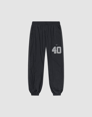 LFDY Performance Trackpants by LIVE FAST DIE YOUNG in black, with elastic waistband and cuffs. Gray reflective "40" and brand print on left thigh, oversize fit. Shown on a plain light gray background. | plain