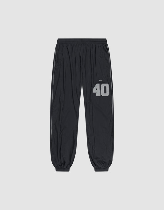 LFDY Performance Trackpants by LIVE FAST DIE YOUNG in black, with elastic waistband and cuffs. Gray reflective "40" and brand print on left thigh, oversize fit. Shown on a plain light gray background. | plain