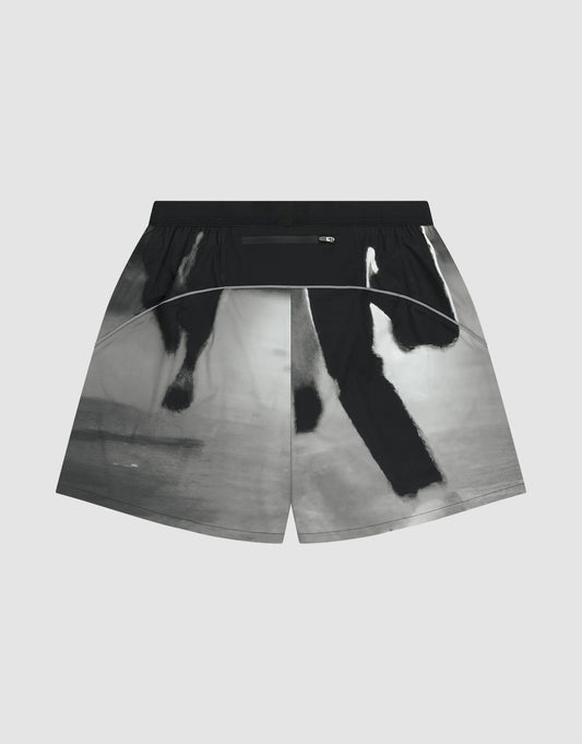 The LFDY Performance Shorts by LIVE FAST DIE YOUNG feature a black and white abstract pattern, a zippered back waistband pocket, and a reflective logo print, shown against a plain light gray background.
