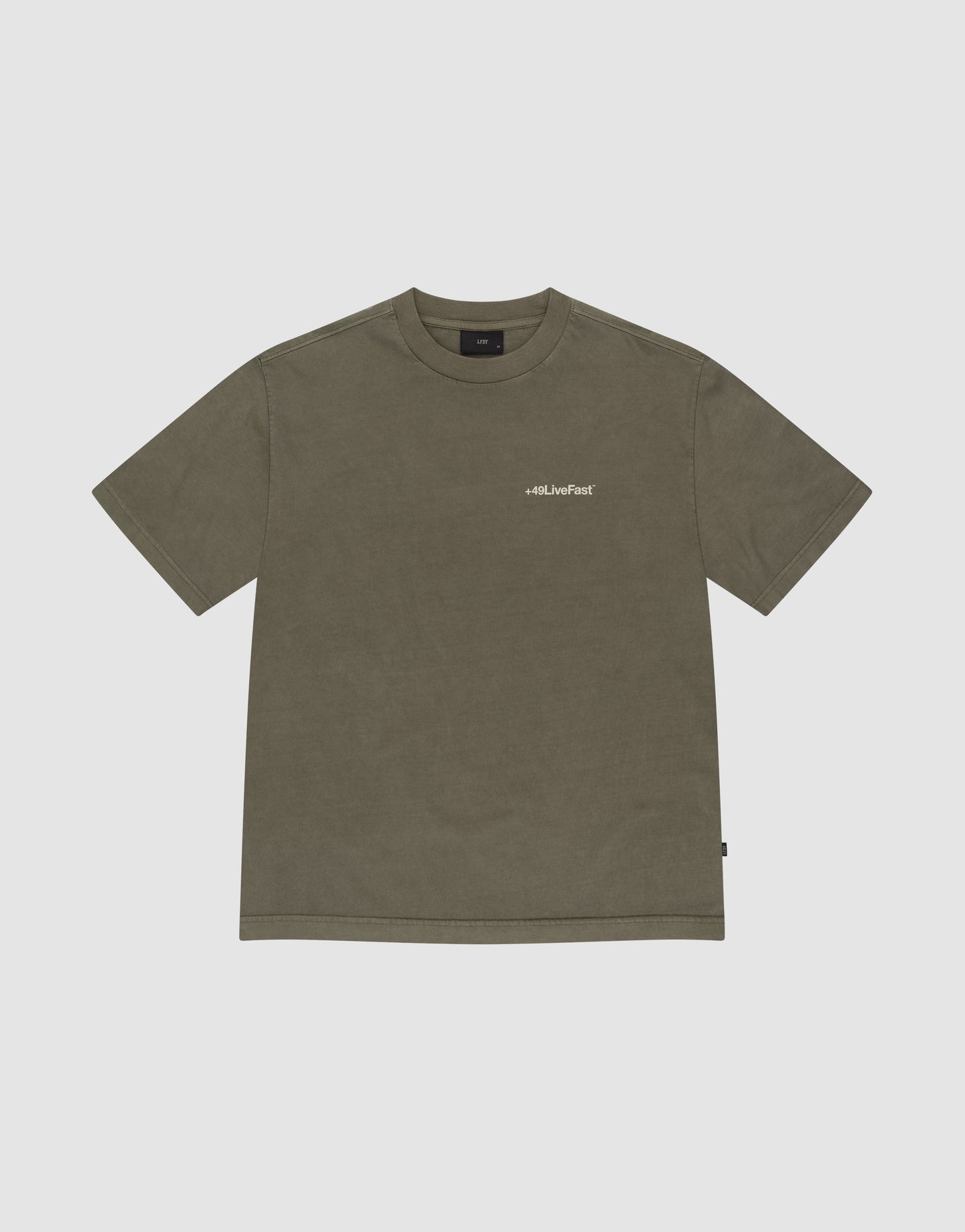 The Basic +49 Chest Tee by LIVE FAST DIE YOUNG is an olive green oversized t-shirt with a crew neck and small white "+49" logo on the left chest, made from 100% cotton and displayed flat on a light gray background.