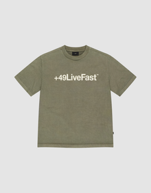The Basic +49 Tee by LIVE FAST DIE YOUNG is an olive green, oversize short-sleeve T-shirt with a bold white +49LiveFast™ front print, made from 100% Baumwolle and shown on a plain light grey background. | plain