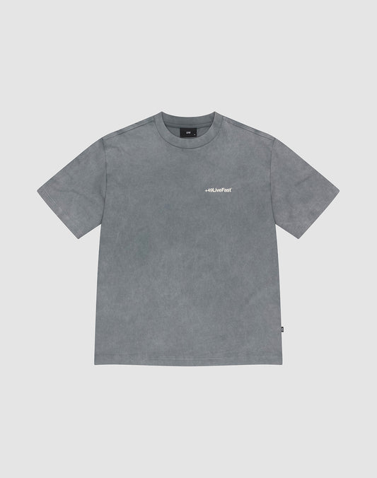 The LIVE FAST DIE YOUNG Basic +49 Chest Tee is a grey, oversized short-sleeve t-shirt with a round neck and a small white “+49” logo on the left chest. Made from 100% Baumwolle, shown on a light grey background. | plain