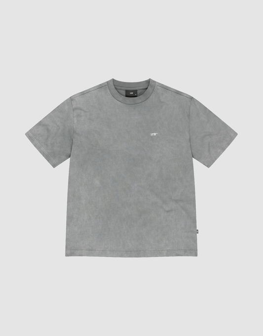 The Basic Trademark Tee by LIVE FAST DIE YOUNG is a gray, short-sleeved crew neck shirt with a small white logo on the upper left chest, made from 100% Baumwolle and displayed flat on a light gray background. | plain