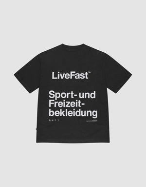 The Basic Trademark Tee by LIVE FAST DIE YOUNG is a black oversize-fit T-shirt with a bold white back print. Made from 100% cotton, it’s shown laid flat on a plain light background, showcasing its eye-catching sporty design. | plain