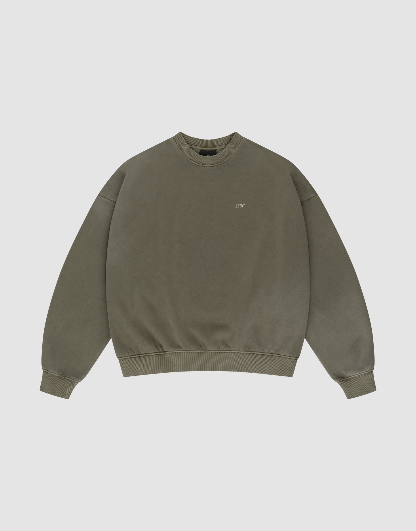 The Basic Chest Sweater by LIVE FAST DIE YOUNG is an olive green, oversize crewneck with long sleeves, ribbed cuffs and waistband, small chest text, and a unique handgefertigter Fade-Effekt. Set against a plain white background.