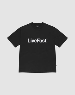 The Basic LiveFast Tee by LIVE FAST DIE YOUNG is a black regular fit T-shirt with a bold "LiveFast™" front print, made from 100% Baumwolle, shown on a plain light gray background. | plain