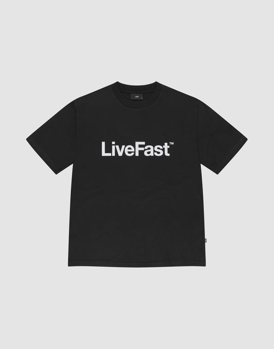 The Basic LiveFast Tee by LIVE FAST DIE YOUNG is a black regular fit T-shirt with a bold "LiveFast™" front print, made from 100% Baumwolle, shown on a plain light gray background. | plain