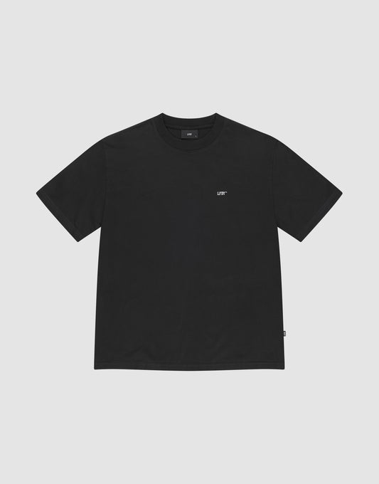 The Basic Chest Tee by LIVE FAST DIE YOUNG is a plain black regular fit, short-sleeve t-shirt in 100% cotton, featuring a small white LIFT logo below the collar. The shirt is displayed flat on a light gray background. | plain
