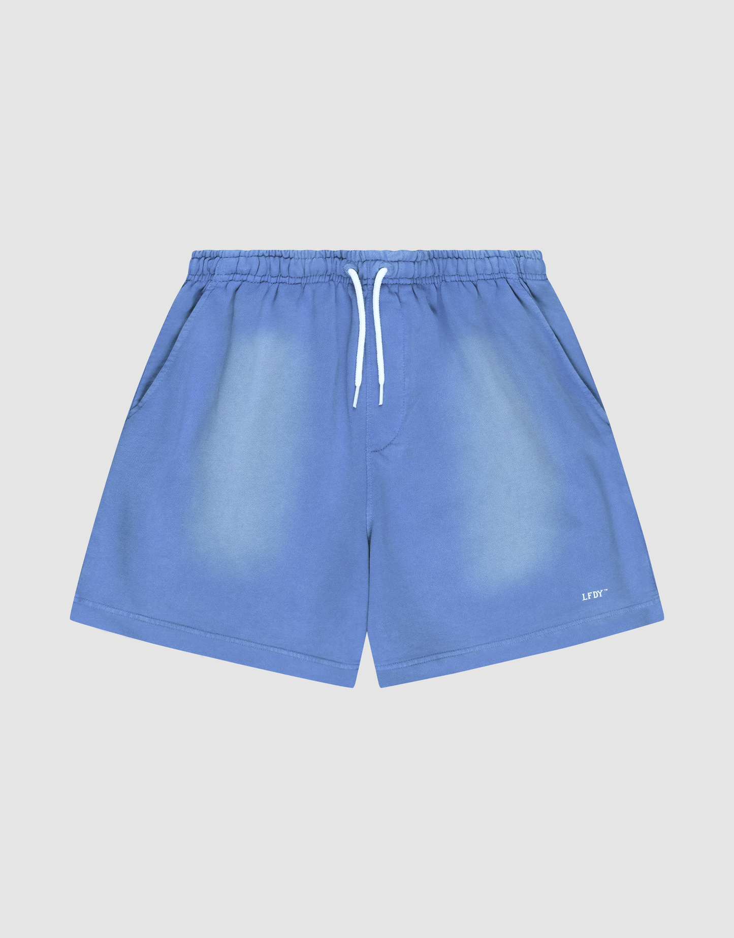 The LIVE FAST DIE YOUNG Basic Sweat Shorts are blue with a faded finish, elastic waistband, white drawstring, angled side pockets, and a small white logo on the lower left leg, shown against a light gray background.