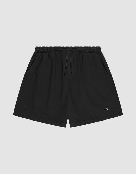 LIVE FAST DIE YOUNG Basic Sweat Shorts in plain black, featuring an elastic waistband, drawstring, side pockets, and a small white logo print on the left leg, shown on a light gray background. | plain