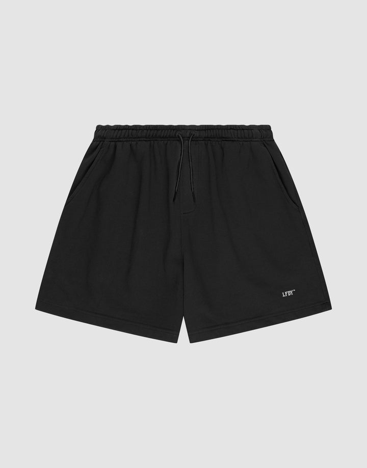 LIVE FAST DIE YOUNG Basic Sweat Shorts in plain black, featuring an elastic waistband, drawstring, side pockets, and a small white logo print on the left leg, shown on a light gray background. | plain