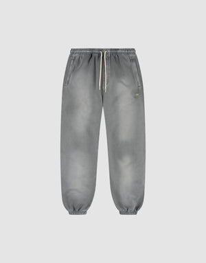 The LIVE FAST DIE YOUNG Basic Loose Jogger is a pair of gray washed sweatpants with a subtle fade effect, elastic waistband and white drawstring, side pockets, and elastic ankle cuffs, shown on a plain light background. | plain