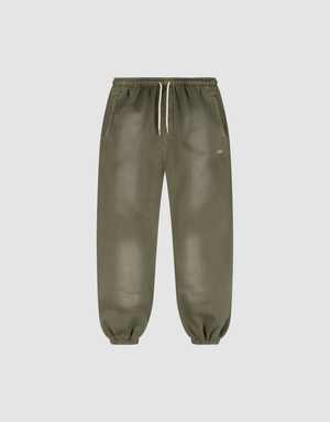 The LIVE FAST DIE YOUNG Basic Loose Jogger features olive green fabric with a handgefertigter Fade-Effekt, an elastic waistband with a white drawstring, side pockets, elastic ankle cuffs, and a small white logo near the left pocket. | plain