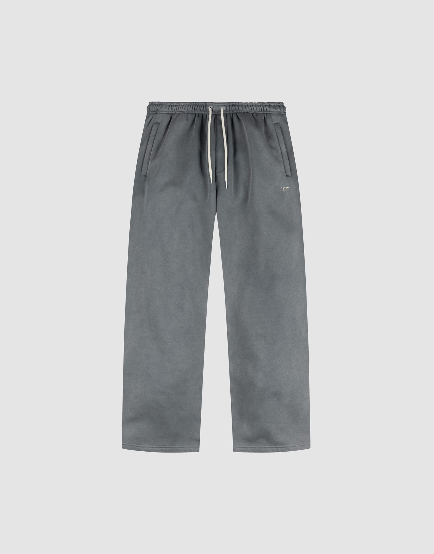 LIVE FAST DIE YOUNG's Basic Wide Jogger is shown flat on a light gray background, featuring an oversized fit, elastic waistband with white drawstring, side pockets, and a minimal design.
