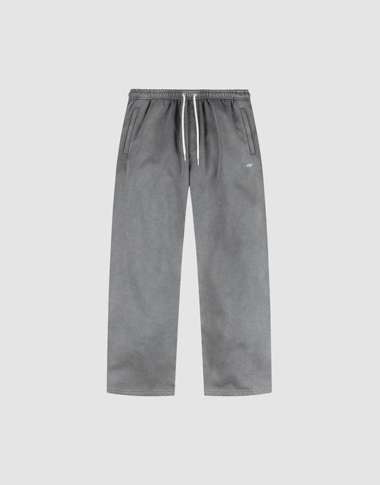 The LIVE FAST DIE YOUNG Basic Wide Jogger features a grey oversized straight-leg design with an elastic waistband, white drawstring, side pockets, and subtle logo print, shown on a plain light background. | plain
