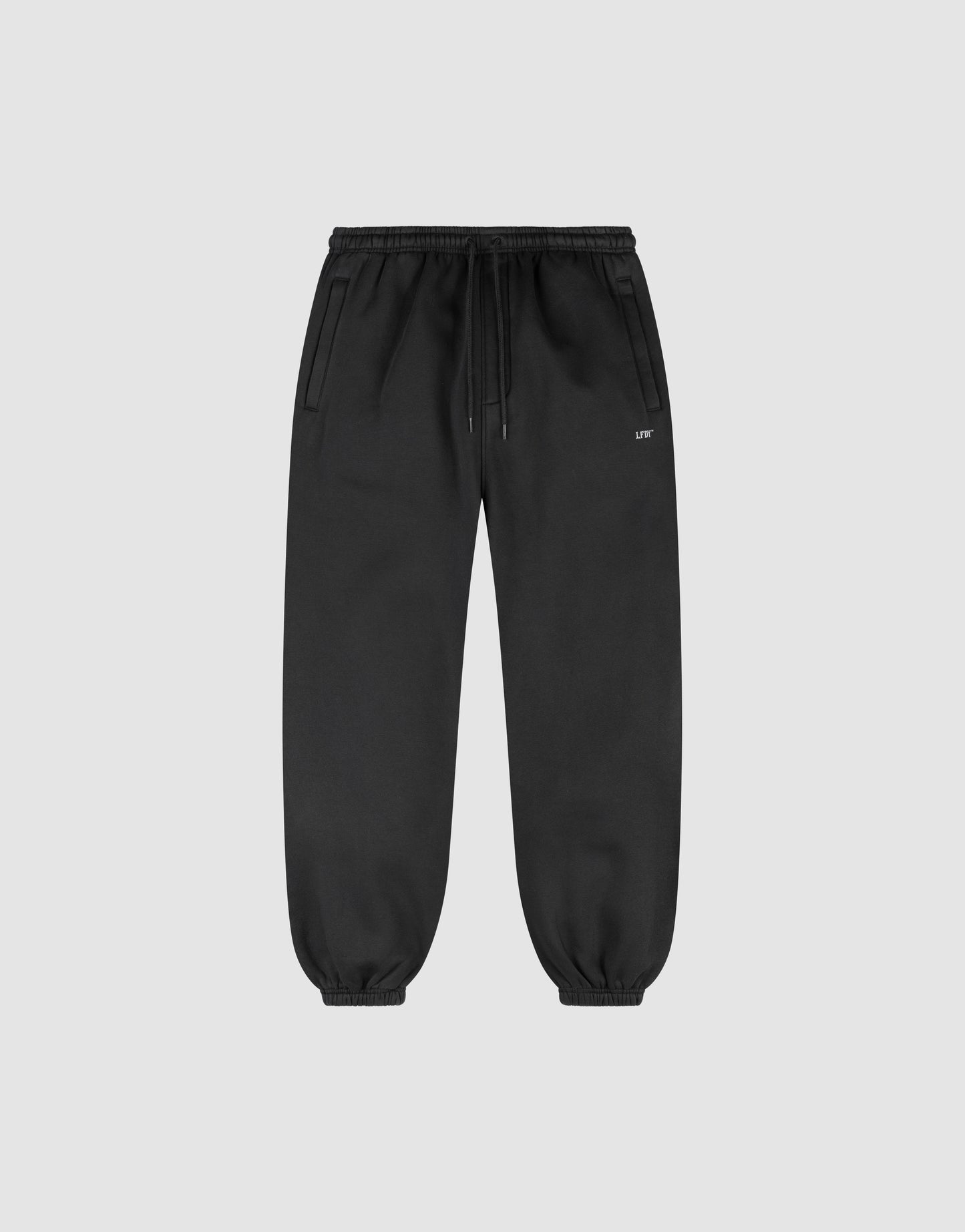 The LIVE FAST DIE YOUNG Basic Loose Jogger features a loose fit, elastic waistband with drawstring, side pockets, and elastic ankle cuffs, shown on a light gray background.