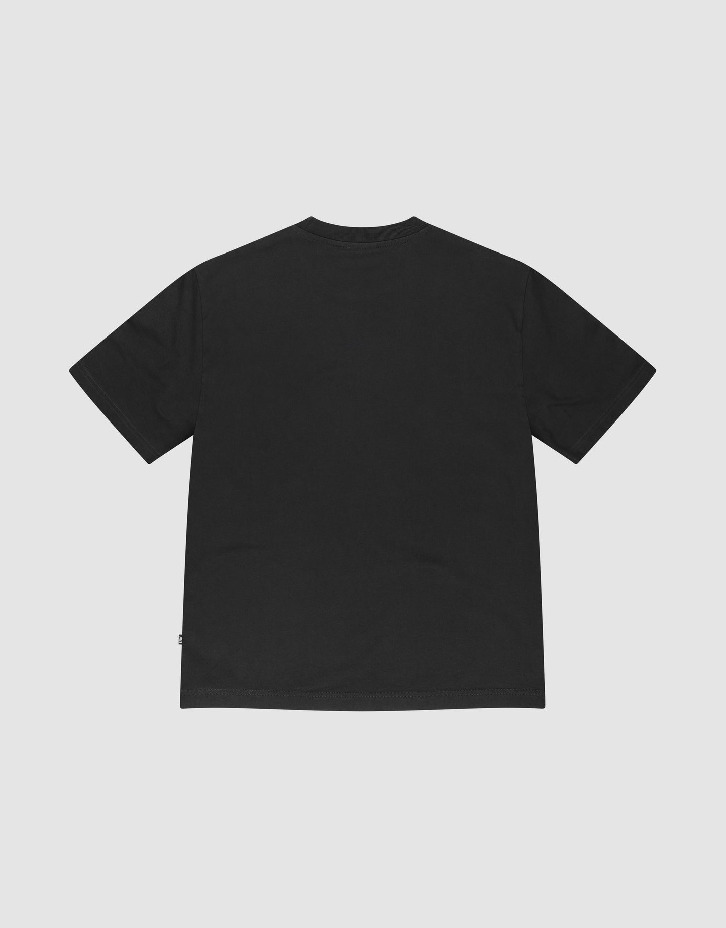 The LIVE FAST DIE YOUNG Basic +49 Tee, an oversize black short-sleeve t-shirt made from 100% Baumwolle, is shown laid flat with the back facing up against a light gray background.