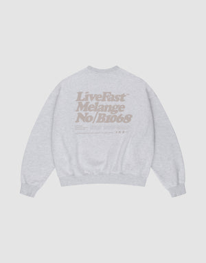 The Basic Melange Sweater by LIVE FAST DIE YOUNG is a light gray cotton sweatshirt with tan "Live Fast Melange No/B1068" backprint, crewneck, oversize fit, long sleeves, ribbed cuffs and hem, plus subtle front and backprint details. | plain