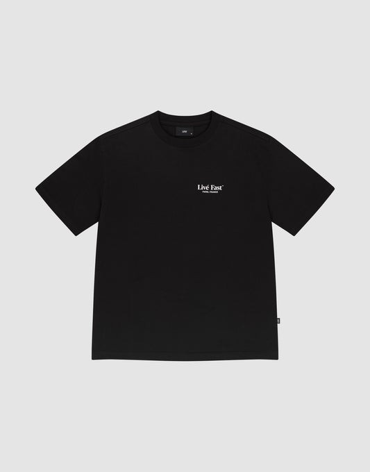 The LFDY Paris Tee by LIVE FAST DIE YOUNG is a black 100% cotton short-sleeve shirt with small white "Live Fast" text on the upper chest, shown on a plain light gray background.