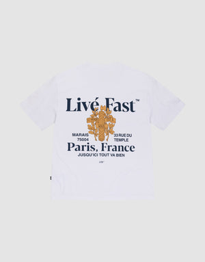 The LFDY Paris Tee by LIVE FAST DIE YOUNG is an oversized white shirt made from 100% cotton, with bold navy "Live Fast" front and back prints, orange graphics, and Paris—33 Rue Du Temple—Marais 75004 details. | plain
