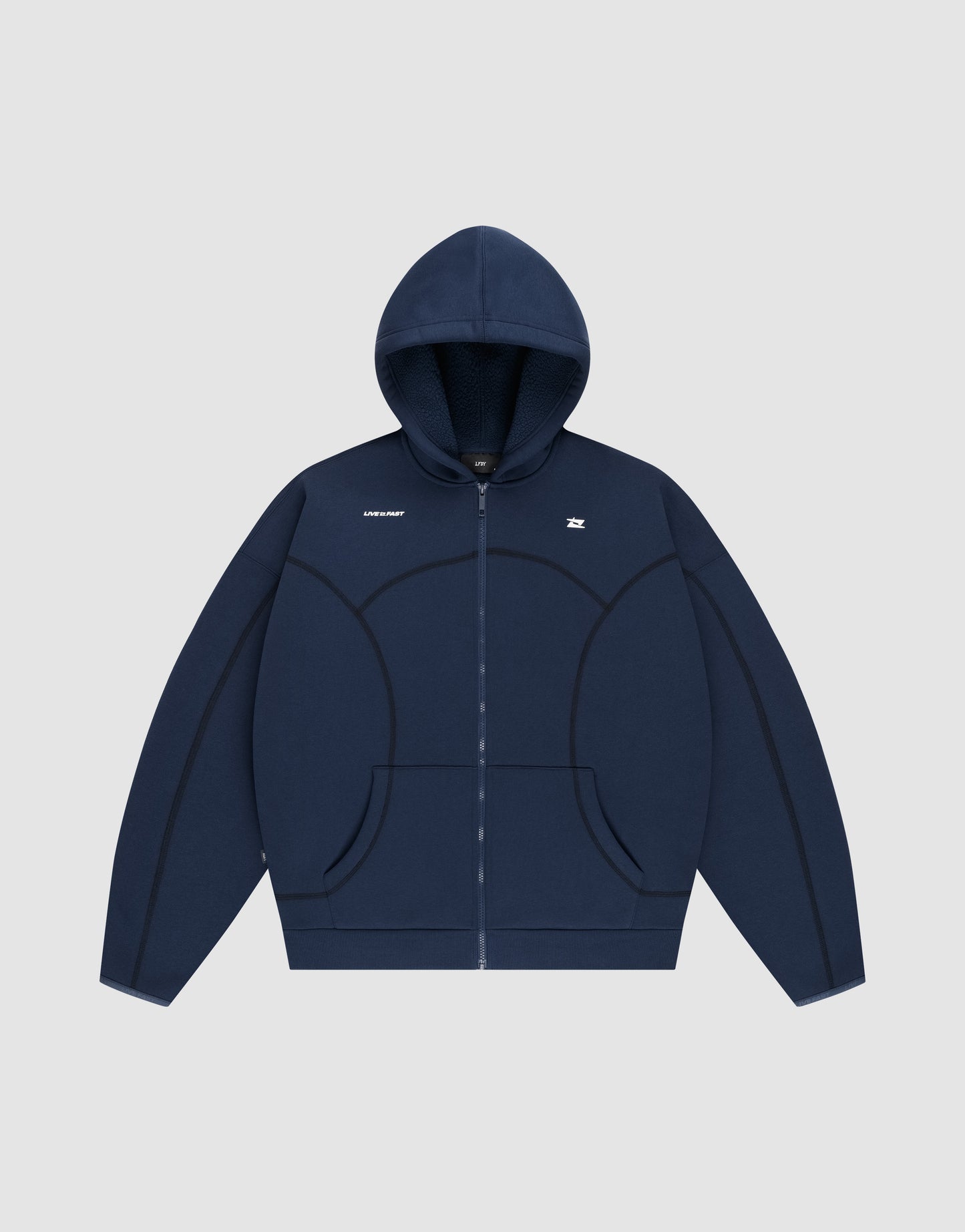 The LFDY Active Fleece Hooded Zip by LIVE FAST DIE YOUNG is a navy blue oversized zip-up hoodie with a hood, front pockets, curved seam details, and small white chest logo. Made from soft Baumwolle for comfort. Photographed on a light gray background.