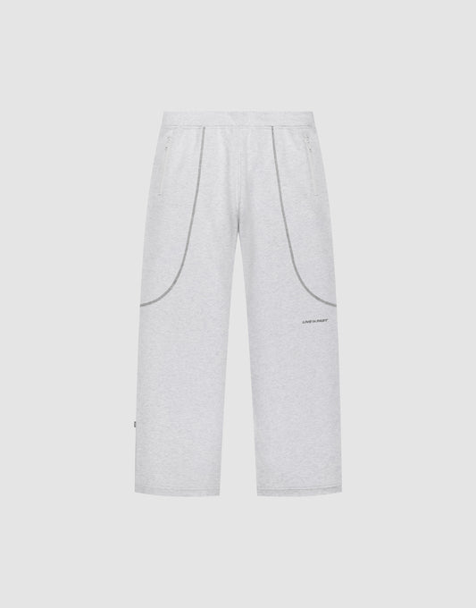 The LFDY Active Fleece Jogger by LIVE FAST DIE YOUNG features a wide fit, light gray color, elastic waistband, two side pockets, curved seam details, and a small logo print on the left thigh, shown on a plain white background. | plain