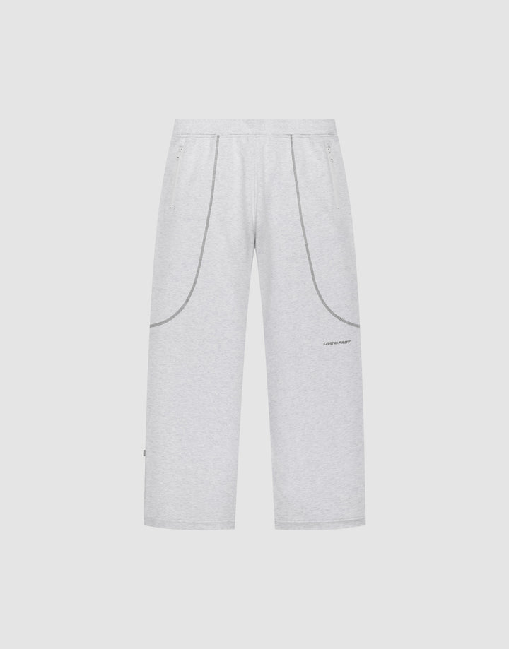 The LFDY Active Fleece Jogger by LIVE FAST DIE YOUNG features a wide fit, light gray color, elastic waistband, two side pockets, curved seam details, and a small logo print on the left thigh, shown on a plain white background. | plain