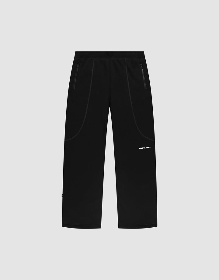 The LFDY Active Fleece Jogger by LIVE FAST DIE YOUNG features a black wide fit, straight-leg design with zip pockets and a small white logo print on the left thigh, displayed on a plain light gray background. | plain
