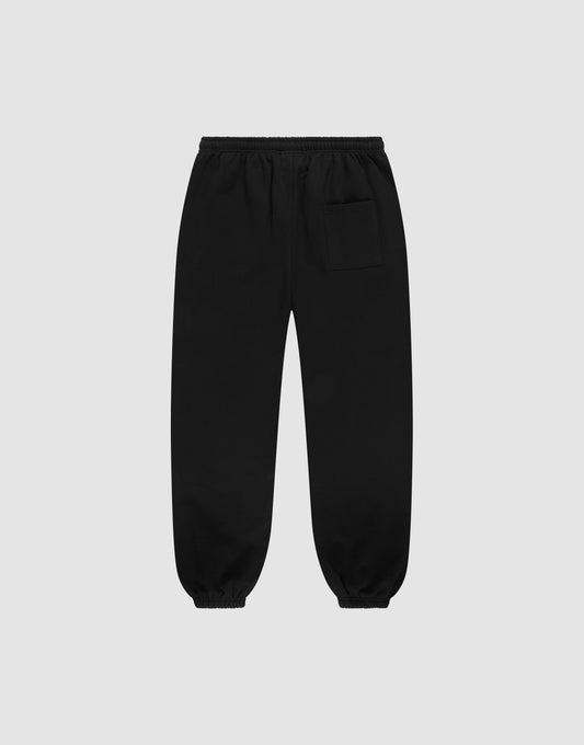 The LIVE FAST DIE YOUNG Wide Cuff Jogger is a black, wide-fit sweatpant made from 100% Baumwolle French Terry, featuring an elastic waistband, cuffs, and a small pocket on the upper right thigh, displayed on a light gray background.