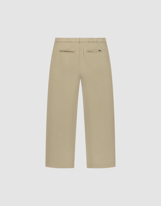 LIVE FAST DIE YOUNG Wide Casual Pants in Beige, Wide Fit, elastischer Bund, zwei seitliche Taschen, zwei Paspel-Rückentaschen und kleiner Reißverschluss an der rechten Tasche – flach auf hellem Hintergrund präsentiert.