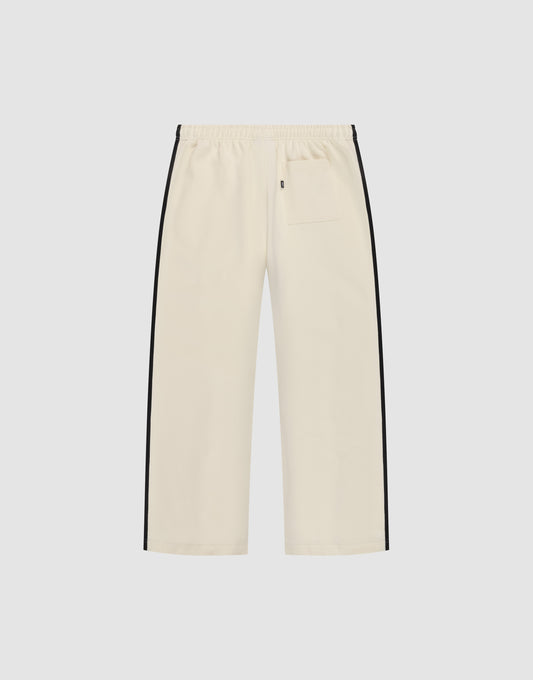 The LFDY Striped Jogger by LIVE FAST DIE YOUNG features a cream color, wide fit, elastic waistband, black herringbone side stripes, and a single back pocket, shown against a plain white background.