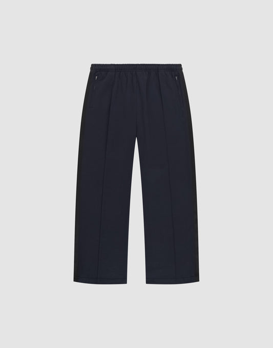 The LFDY Striped Jogger by LIVE FAST DIE YOUNG is a pair of black, wide-leg pants with an elastic waistband and zippered side pockets, featuring subtle Fischgräten-Tape accents, shown on a plain white background. | plain